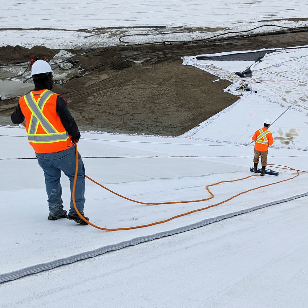 Men on a geomembrane doing leak location at the Laronde mine